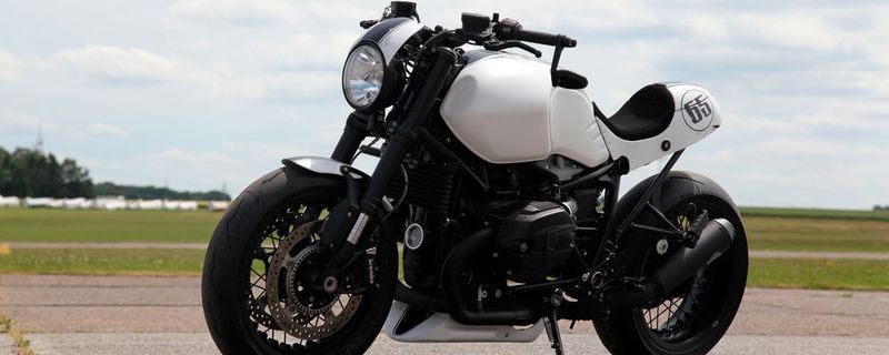 Die BMW RnineT Custom nach Fertigstellung auf dem Flugplatz in Bonn. Blinker und Rücklicht von Kellermann, ein Auspuffsystem von Dr. Jekill & Mr. Hyde, ein personalisiertes Typenschild und größtenteils in Weiß gehalten: Das Geburtstagsgeschenk für Franz Berrendorf von MBT an sich selbst.