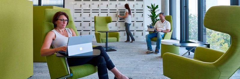 Große grüne Sessel mit einem kleinen Tisch daran befestigt, um den Laptop abzustellen, Ausblick ins Grüne durch die wandgroßen Fenster und Stille im gesamten Raum. Sieht er so aus, der Arbeitsplatz der Zukunft?