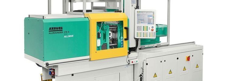 Arburgs spezielle Mikroproduktionszelle mit elektrischem Allrounder, Mikrospritzeinheit und Roboter in einem System.
