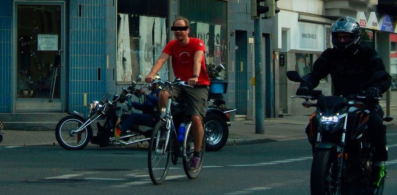 Ein nicht ganz alltägliche Verkehrssituation: Trike, Fahrrad und Motorrad - mit drei ganz unterschiedlichen Kopfbedeckungen. Man beachte den Fahrer im Hintergrund mit der goldenen Pickelhaube.