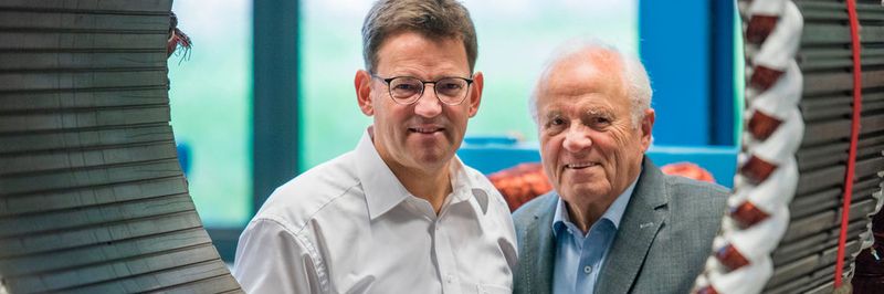 Die modernen Torquemotoren von Johannes (l.) und Bernhard Oswald – hier schauen sie durch einen gewickelten Stator – verringern den Energieverbrauch um bis zu 50 %, der Einsatz von Getriebeöl fällt weg und die Maschinen werden leichter. Dafür hat sie der DBU geehrt.