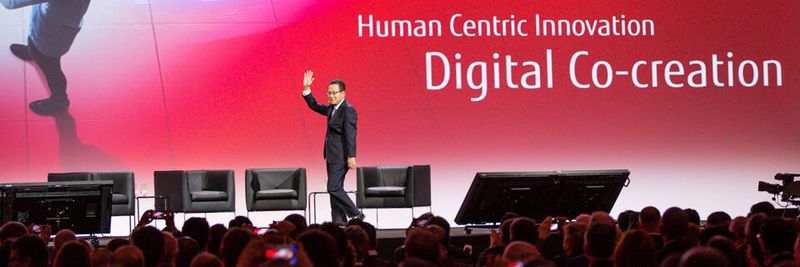 Tatsuya Tanaka, Präsident Fujitsu, vor vollem Haus beim jährlichen Kunden- und Partnergroßevent.