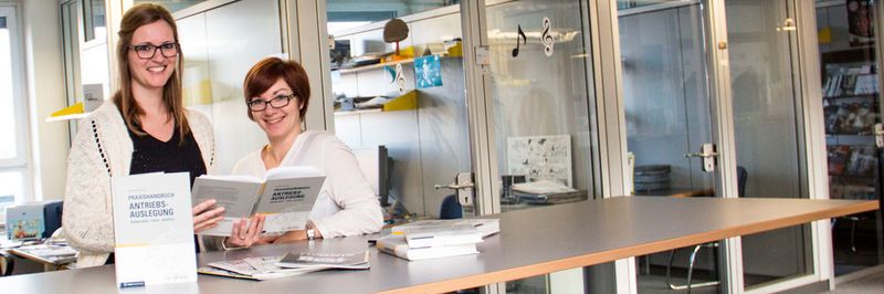 Die Redakteurinnen Sandra Häuslein und Juliana Pfeiffer (v.l.) aus dem Team der konstruktionspraxis schauen sich die 2. Auflage des Praxishandbuchs Antriebsauslegung von Reinhard Mansius an, das im hauseigenen Buchverlag erschienen ist.