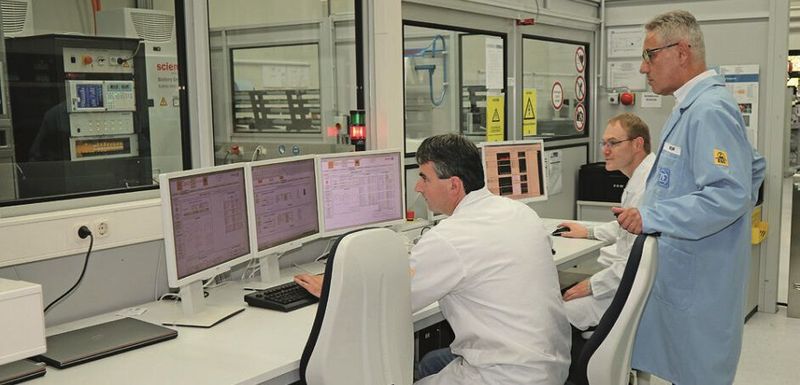 Martin Högner und Markus Toesko (ZF) erklären Johann Mathä (Yokogawa) den Prüfstand. Aus Sicherheitsgründen sind der Steuerstand und der Prüfstand durch eine Schutzwand getrennt.