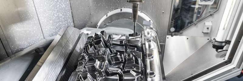 Arbeitsraum des C 52 U mit dem NC-Schwenkrundtisch mit 700 mm Durchmesser und für Traglasten bis 2000 kg; hier bestückt mit einem grossformatigen Grundwerkzeug, das 5-achsig finish- bearbeitet wird.