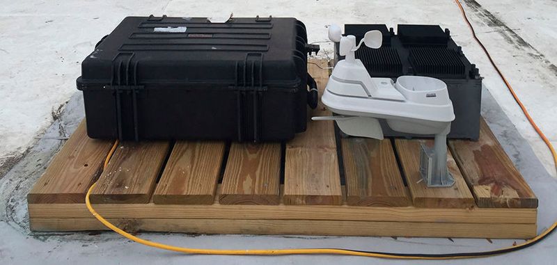 Der Testaufbau, mit dem Forscher im Verlauf mehrerer Monate ihr Prinzip des neuen Energiegewinnungskonzeptes auf dem Dach eines MIT-Gebäudes unter Beweis stellten: Das Testgerät selbst ist der schwarze Kasten auf der rechten Seite, der hinter einem Wetterüberwachungssystem (weiß) platziert ist. Einer Reihe von Testgeräten (größeres schwarzes Gehäuse links) überwacht die Geräteleistung.