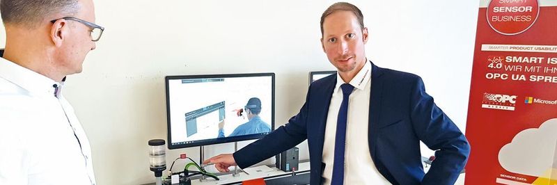 Michael Mayer-Rosa (re.) zeigt an einem Modell einer Transportstrecke die verbauten Smart-Core-Kabel, deren Ausfall dort simuliert werden kann.
