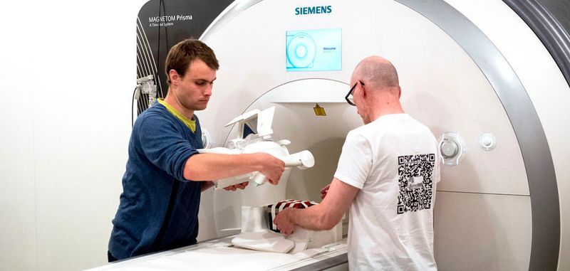 Die Mitarbeiter von Preisträger Jens Frahm, Volkert Roeloffs (l) und Kurt Böhm, legen eine Kopfspule, mit der sie Gewebeeigenschaften simulieren, in ein Magnetresonanztomograph (MRT). Frahm ist am 07.06.2018 in Paris mit dem Europäischen Erfinderpreis ausgezeichnet worden.