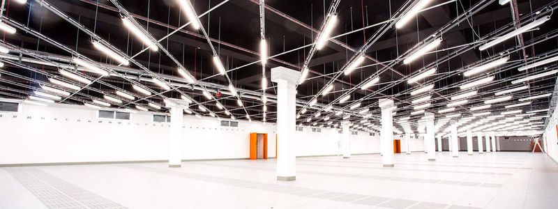 Der leerer Rechnersaal des „FDC1“ mit schwarz gestrichener Decke ist mit einem diagonal angebrachtem LED-Leuchtensystem versehen, das sensorgestützt nur da Licht erzeugt, wo sich jemand bewegt.