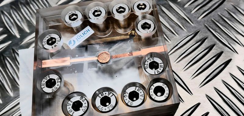 Testaufbau für die Festkörperbatterie: Die Batterie von der Größe einer Knopfzelle befindet sich in der Mitte des Plexiglasgehäuses, welches die dauerhafte Kontaktierung der Batterie sicherstellt.