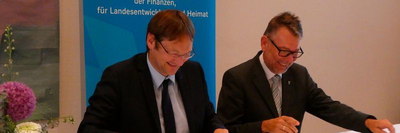 Der Bayerische Finanz- und Heimatstaatssekretär Dr. Hans Reichhart (l.) und der Thüringer Finanzstaats-sekretär und CIO Dr. Hartmut Schubert bei der Vertragsunterzeichnung