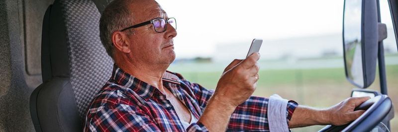 Geht gar nicht: Ein Berufskraftfahrer schreibt am Steuer seines Lastkraftwagens in aller Seelenruhe eine SMS.