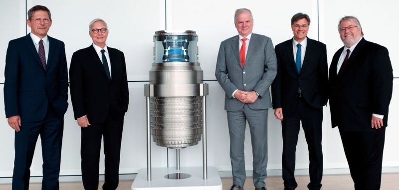 Prof. Dr. Michael Kaschke, Vorstandsvorsitzender von ZEISS, Prof. Dr. Dieter Kurz, Vorsitzender des Aufsichtsrats der Carl Zeiss AG und Vorsitzender des Stiftungsrats der Carl-Zeiss-Stiftung, Martin van den Brink, President und CTO von ASML, Dr. Karl Lamprecht, Mitglied des Vorstands von ZEISS und Leiter der Sparte SMT, und Dr. Herbert Zeisel, Minsterialdirigent in der Abteilung Schlüsseltechnologie für Wachstum beim BMBF (v.li.), vor dem Modell eines Starlith-19xyi-Objektivs von ZEISS.