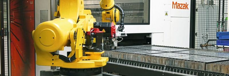 Die Gardena-Klingen und -Messer werden auf einer Flachbett-Laserschneidanlage aus den Platinen herausgeschnitten. Der Roboter nimmt die Teile einzeln auf und setzt sie auf dem Einlauf-Transportband der Entgratmaschine ab.