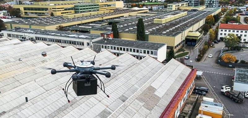 Erste automatisierte Werksdrohne in Deutschland: Eine automatisierte Lieferdrohne über den Dächern der Werkshallen des ZF-Werks 2 in Friedrichshafen. Sie bringt ein dringend benötigtes Ersatzteil auf dem Luftweg in die Instandhaltungswerkstatt.