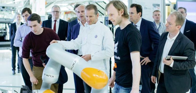 Die Gründer von Wandelbots demonstrieren vor VW-Vorständen eine vom Startup traineirte Wandelbox gelehrte Industriemontageanwendung. Das Startup, eine Ausgründung der TU Dresden, hat sich nun in einer Finanzierungsrunde 6 Millionen Euro Investmentkapital gesichert.