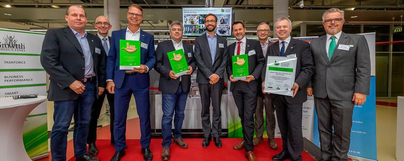 Die Gewinner der Lean & Green Management Awards 2018 (v. l.): Alan Brunhammer, Quadriga Consult; Jörg Cwojdzinski, ASM Assembly Systems (Gastgeber); Wolfgang Thomar, Alfred Kärcher; Thomas Ebenhöch, Continental Regensburg; Daniel Reichert, Growtth Consulting Europe; Gerd Pahlisch, Lohmann & Rauscher; Willi Regh, Growtth Consulting; Jürgen Bonn, Lohmann & Rauscher; Ernst Forstmayr, Growtth Consulting.