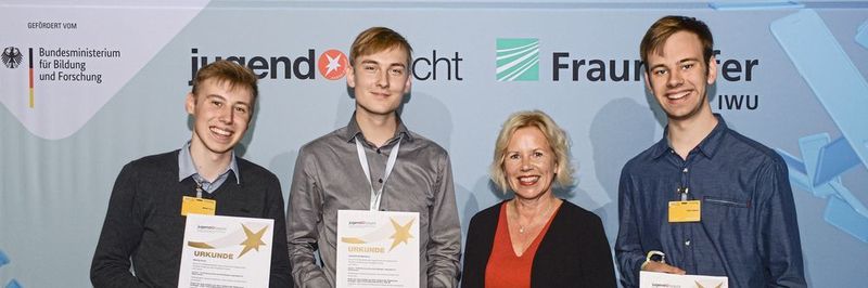 Moritz Kunz, Leonard Sondermann und Felix Ulonska (v.l.n.r.) aus Münster entwickeln ein cleveres Ladenetz für Elektroautos und erhielten dafür den VDE-Sonderpreis, den Ihnen Sabine Schattke (Mitte) vom VDE übergab.