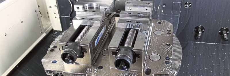 Die Gredoc Wechsel-Grundplatte mit 10 Nullpunkt-Spannstationen liegt in einem 5-Achsen-CNC-Bearbeitungszentrum; montiert sind hier zwei Einfach-Spanner Gripos.
