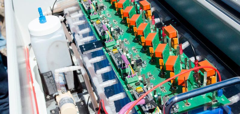 Der Demonstrator des Speichers soll seinen Aufbau verdeutlichen. Die blauen Kästen sind die Zellen, im Gefäß links befindet sich das Elektrolyt, das durch die Schläuche weitergeleitet wird.