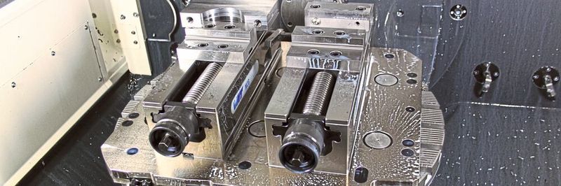Die Gredoc Wechsel-Grundplatte mit 10 Nullpunkt-Spannstationen liegt in einem 5-Achsen-CNC-Bearbeitungszentrum; montiert sind hier zwei Einfach-Spanner Gripos.