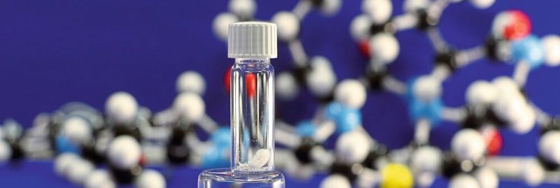 Im Labor synthetisiertes Lugdunin, im Hintergrund das Strukturmodell.