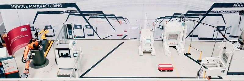 The pilot plant set-up in the NextGenAM project for automated additive manufacturing in detail, from left to right: Band saw, Kuka robot, behind it: 3D measuring station (Geometric Optical Measurement / GOM), set-up station, unpacking station, in front of it: Transport vehicle (AGV), EOS M 400-4, not in the picture: Powder Station IPM M Powder Station L from EOS.