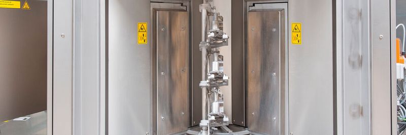 Zum Reinigen setzt der Roboter je drei Drosselklappen auf die speziell gefertigten Werkstückträger; sie rotieren automatisch durch die Teilereinigungsanlage.