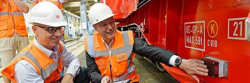 Marek Staszek, Produktionsvorstand bei DB Cargo, und Dr. Jürgen Harland, Leiter Logistik und SCM bei Salzgitter Flachstahl (v.l.), aktivieren die Telematikbox am 34.000. „Intelligenten Güterwagen“.