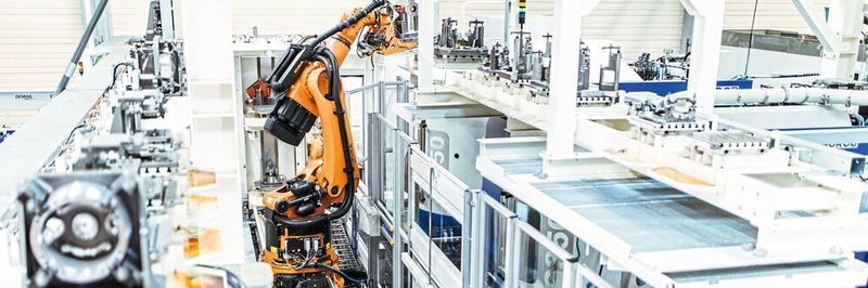 Drei Werkzeugmaschinen des Herstellers Grob bearbeiten Roboterwerkstücke. Ein KR Fortec fährt diese über eine Lineareinheit zum Be- und Entladen an.
