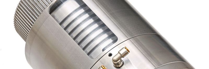 Kugelgewindetrieb mit gekühlter angetriebener Mutter (Öffnung im Kühlgehäuse zur Veranschaulichung): In der Spirale zirkuliert das Kühlmedium, das die aus Lagerreibung und Kugelkontaktbereich entstehende Wärme ableitet.