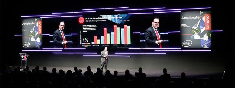 Wilfredo Sotolongo, Chief Customer Officer Lenovo Data Center Group, kündigt auf der „Accelarate 2019“ in der „BWW Welt“ Jörn Kellermann von T-Systems an, der die Kooperation bezüglich „Future Cloud Infrastructure“ vorstellt.