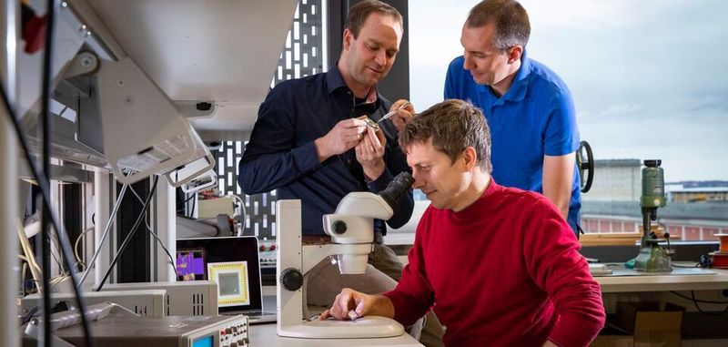 Ein Blick ins Labor: Forscher der TU Chemnitz um Marko Rößler (am Mikroskop) haben einen hocheffizienten Mikrochip zur exakten Positionsbestimmung in Gebäuden entwickelt.