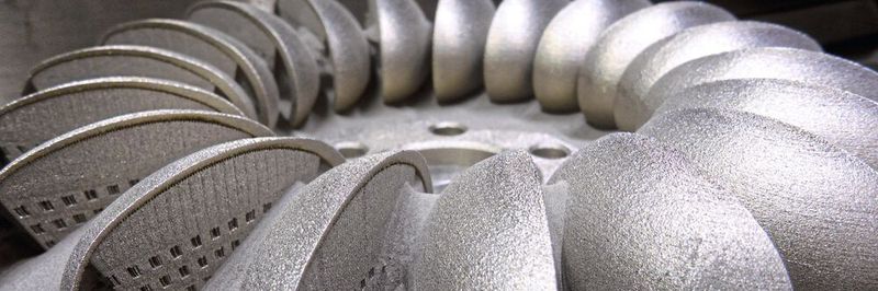 An der aus Pulver erzeugten Radhälfte werden die Supports – die beim Herstellen die Schaufeln stabilisieren – später entfernt, das Bauteil wird vom Metallträger getrennt und mit dem spiegelbildlichen zweiten Bauteil zum kompletten Schaufelrad verbunden.