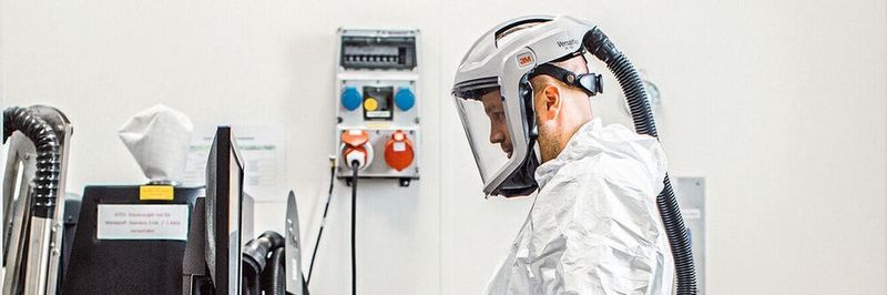 Der Evonik-Anlagenführer David Fuchs füllt im Schutzanzug Metallpulver ein. Aus Edelstahlpulver gedruckte Reaktoren sind laut Evonik ein Novum in der chemischen Industrie.