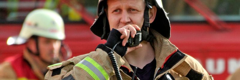 Feuerwehrmann mit BOS-Digitalfunkgerät