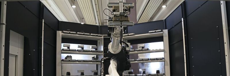 Blick in den BMO Titanium 180. Im Vordergrund eine Schublade mit Fertigteilen, in der Bildmitte der 6-Achsen-Roboter, im Hintergrund die Paletten, auf denen schwerere Bauteile gespannt werden.