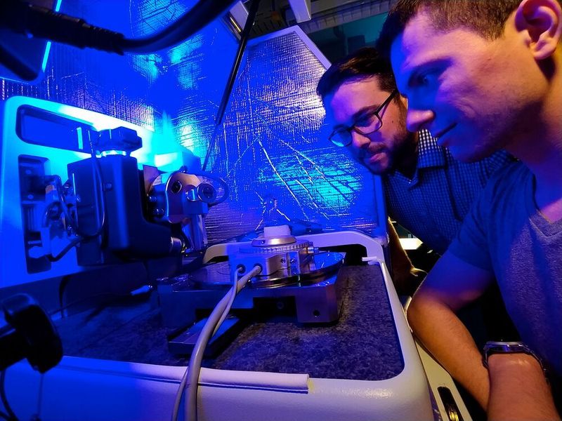 Der Materialwissenschaftler Florian Schäfer (links) und sein Kollege Patrick Grünewald mit einem Hochtemperaturprüfsystem am Rasterkraftmikroskop.