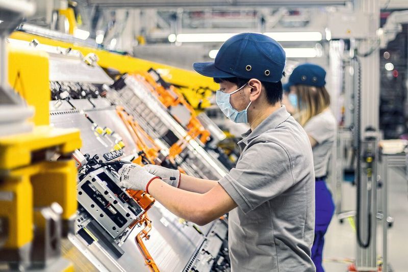 Symbolisch für den Hochlauf nach der Krise: Werker in der Produktion mit Maske. Doch nicht jedes Unternehmen erholt sich von der Zwangsauszeit.