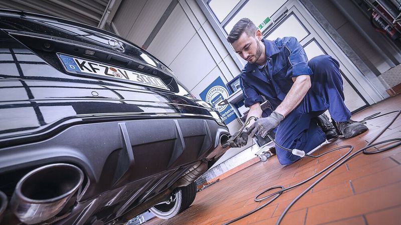 Ein Prüfer einer anerkannten Kfz-Fachwerkstatt führt eine AU durch.