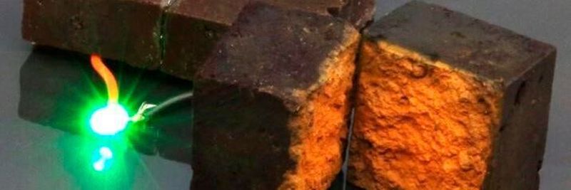 The brick supercapacitor device developed by researchers in the U.S. is shown here powering a green light-emitting diode.