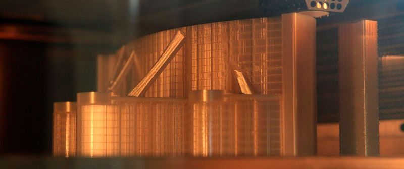 Blick in den Bauraum eines FDM-Druckers: Die Extruderdüse erhitzt ein Filament und bringt es Schicht für Schicht auf.