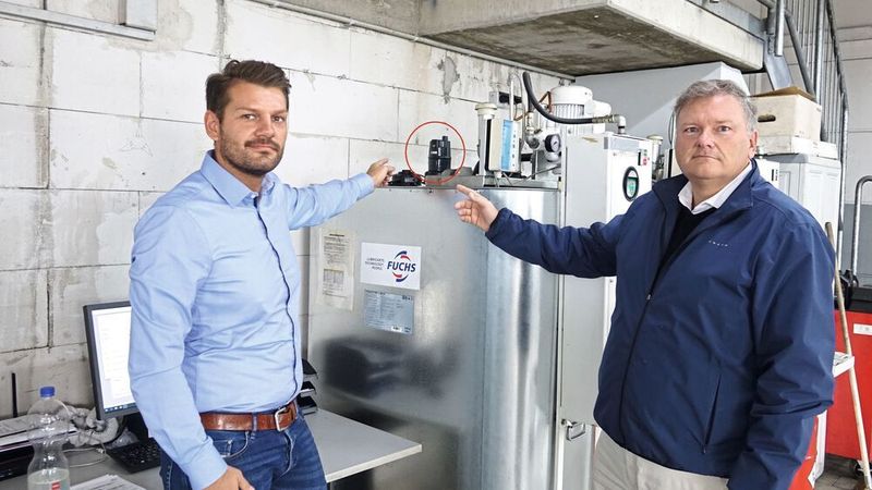 Henrich Vogel (li.) von Fuchs Schmierstoffe hat Autohausbesitzer Markus Mattusch (re.) dank des „Smart Level“ (Kreis) das Motoröl-Handling massiv erleichert. Die kleine Einheit checkt jeden Tag den Tankinhalt und löst bei Bedarf selbstständig eine Ölnachbestellung aus.