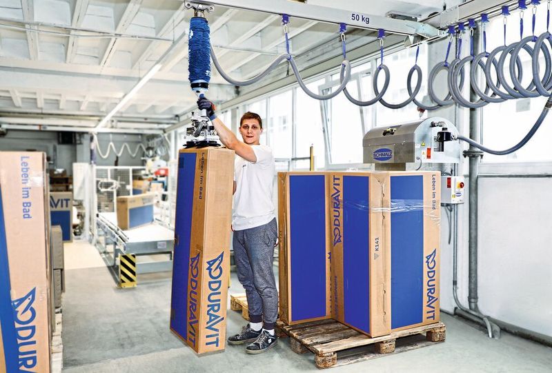 Fertig für das Einlagern: Mit dem Vakuum-Schlauchheber JumboFlex werden selbst unhandliche Kartons im Format von 50 cm x 150 cm von der Rollenbahn auf die Palette transportiert.