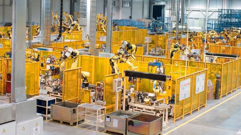 Industrieautomation: Produktionslinie mit Roboterarmen in einer Fabrik.