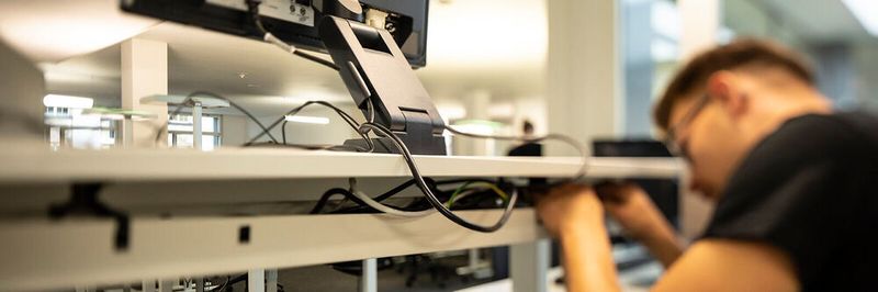Die Arbeitsplatzausstattung wirkt sich auf die Produktivität der Mitarbeiter aus. Trotzdem sparen manchen am Falschen. Auch das eine Notebook, das auf vielen Werbebildern auf einem ansonsten leeren Schreibtisch steht, ist falsch.
