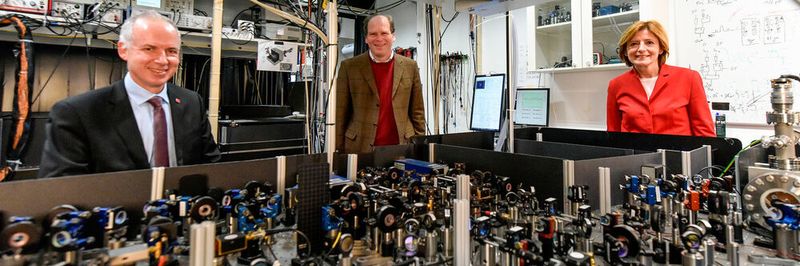 Im Quantencomputer-Labor: Prof. Dr. Ferdinand Schmidt-Kaler (Mitte) erläutert Ministerpräsidentin Malu Dreyer und Präsident Prof. Dr. Georg Krausch ein System von Präzisionslasern zum Steuern eines Quantencomputers.