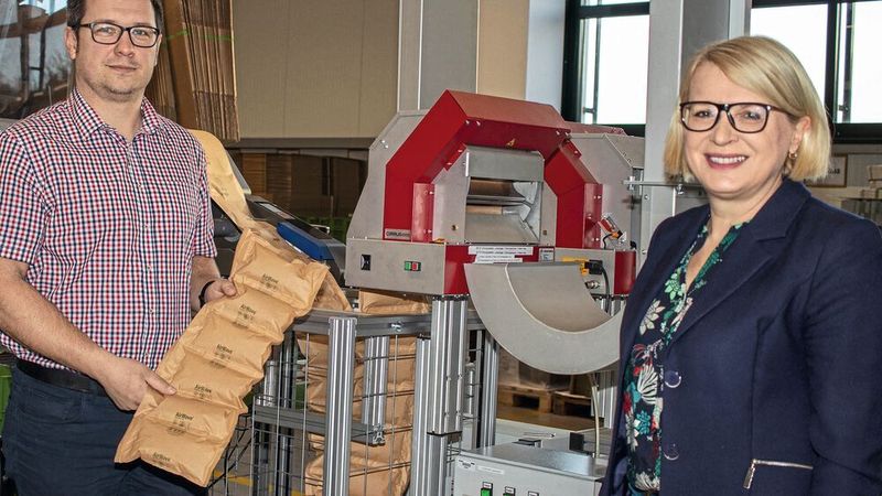 Umweltschutz: Diana Wilhelm, Head of Corporate Logistics und Gerrit Kranholdt, Leiter Global Distribution Center, präsentieren die neuen Papierluftpolster, die automatisch an den Pick-Platz geblasen werden.