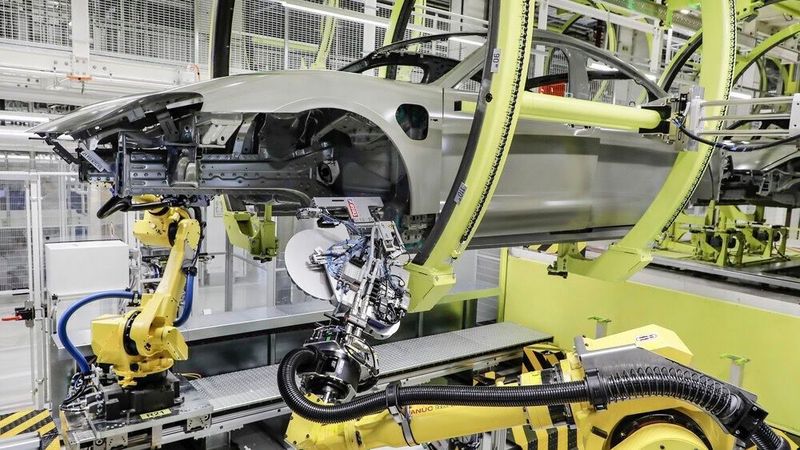 Roboter verschließen beim Taycan künftig die Löcher für die Hohlraumversiegelung der Karosserie mit Klebepads.