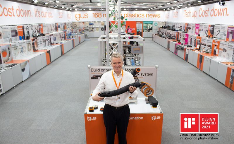 Geschäftsführer Frank Blase zeigt die revolutionäre TRX-Roboter-Energiezuführung auf dem komplett erneuerten physisch-virtuellen Messestand von Igus in Köln, der gerade mit dem „iF Communication Design Award 2021“ prämiert wurde.